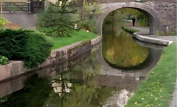 Scene of one of Llangollen Canal's historic stone bridges and the beautiful scenery on the canal side.